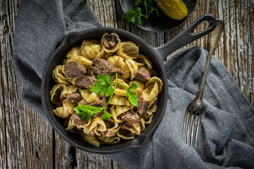 Italian pasta shells with beef sauce in cast iron pan.