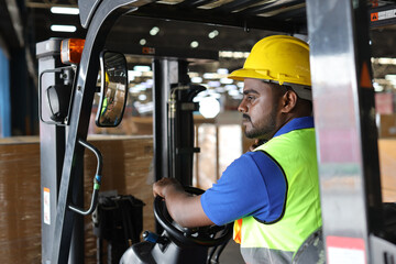 Warehouse workers or forklift driver man with hardhats and reflective jackets in vehicle using walkie talkie radio controlling stock and inventory in retail warehouse logistics, distribution center
