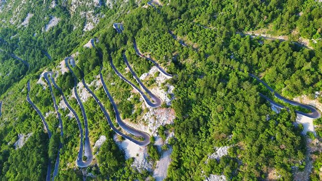Winding road - Lovcensky serpentine with dangerous turns that leads to the top of the Montenegrin mountains covered with vegetation