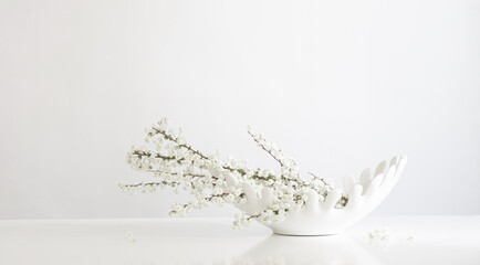 white spring flowers in ceramic white  vase on white background