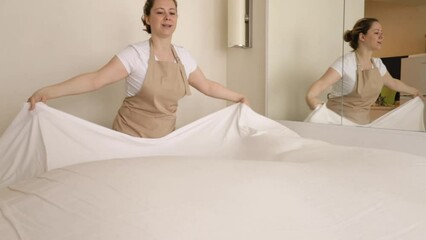maid hands making bed, cleaning service, chambermaid in bedroom straightens bed linen