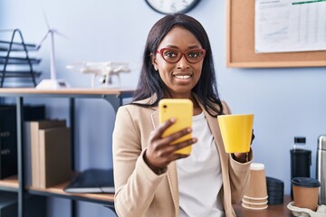 Young african american woman business worker using smartphone drinking coffee at office