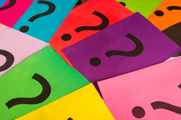 Black question marks on the colored papers