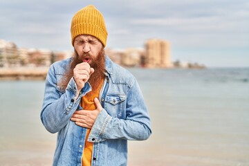 Young redhead man coughing at seaside