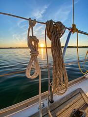 Seile, Taue und Tauwerk auf einer Segelyacht im Sonnenuntergang