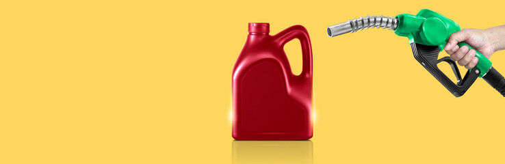 Hands holding Fuel nozzle and bottle of engine oil on yellow background