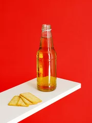 Zelfklevend Fotobehang Longneck beer bottle and Cracker Biscuit isolated on red background © Jingluo/Wirestock Creators