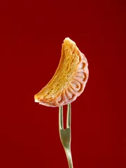 Foto op Plexiglas Closeup of a cookie slice with a floral ornament stamp on a maroon background © Jingluo/Wirestock Creators