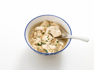 Close-up shot of Tom Kha Gai in a bowl on white background