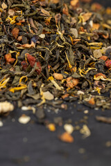 A large amount of dry green tea with pieces of fruit
