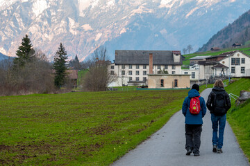 Fototapeta na wymiar two women walking in Glars, Switzerland with the alps in the background