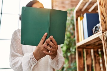 Obraz premium Young latin woman reading book at home