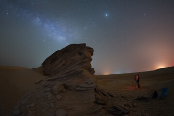 Fototapeta na wymiar Fossil Rock dune in the desert of empty quarter at night milky way while camping