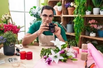 Young hispanic man florist make photo to bouquet of flowers at flower shop