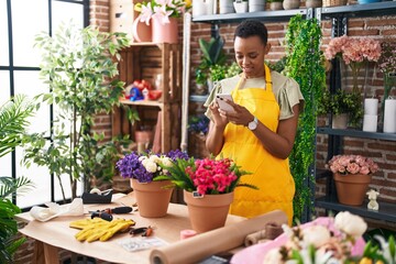 African american woman florist make photo to plant by smartphone at florist