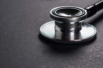 Stethoscope medical instrument on dark background close up