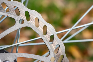 Bicycle disk brake rotor in focus. Metal details of transport concept