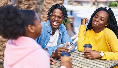 African american friends having breakfast sitting on table at coffee shop terrace