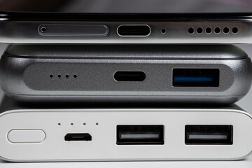 Powerbank for charging mobile devices on white. Smartphone with power bank. External battery for mobile devices