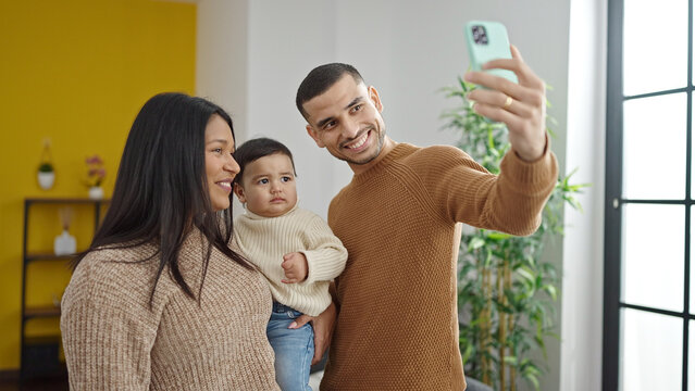 Couple and son make selfie by smartphone standing at home