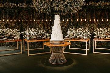 Five-tier white minimalistic wedding cake on a table in a restaurant