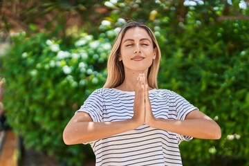 Young blonde woman doing yoga exercise at park