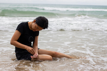 Black-clad woman relaxing on the sand beach with copy space and a sea background.