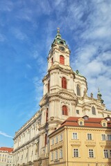 Fototapeta na wymiar Vertical low angle shot of the historic St. Nicholas Church against a bright blue sky in Prague