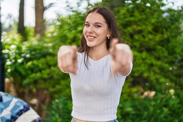 Young woman smiling confident pointing with fingers at park