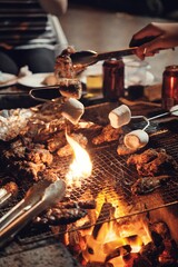 Vertical shot of delicious meat on a grill and marshmallows being roasted at a gathering
