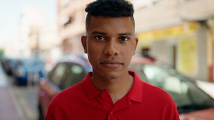 Fototapeta premium Young latin man with relaxed expression standing at street