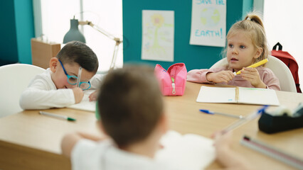 Group of kids students sitting on table drawing on notebook at classroom