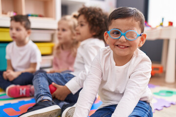 Group of kids sitting on floor smiling confident at kindergarten