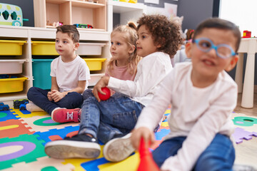 Group of kids sitting on floor smiling confident at kindergarten