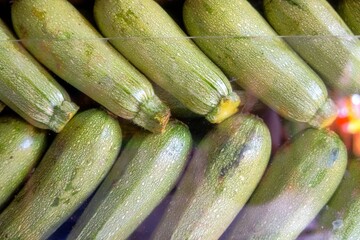 Pile of Cucurbita pepo behind a glass shelf in a store