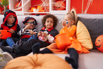 Group of kids wearing halloween costume eating candies at home