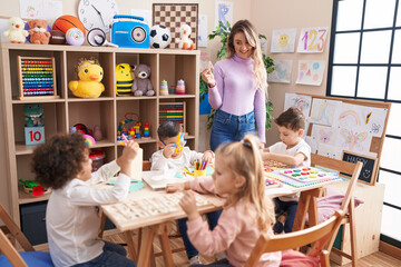 Woman and group of kids having vocabulary lesson at kindergarten - obrazy, fototapety, plakaty