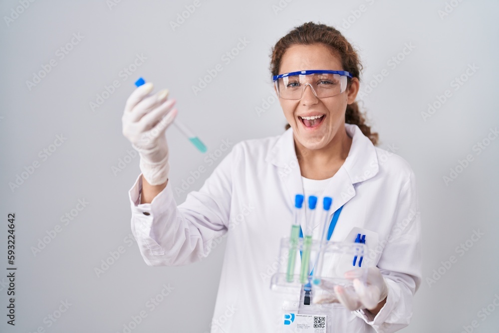 Sticker Young caucasian scientist woman working with laboratory samples celebrating crazy and amazed for success with open eyes screaming excited.