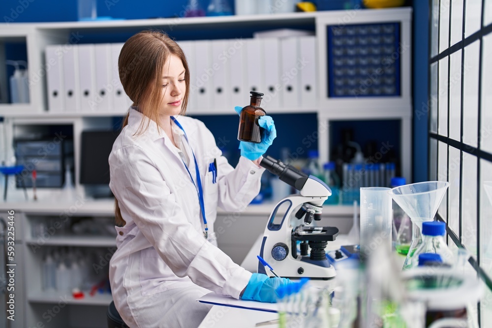 Sticker Young caucasian woman scientist write on document holding bottle at laboratory