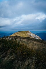 Vertical shot of the rocky peaks of the mountain with the gloomy cloudy sky in the background