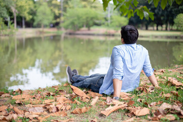 Young caucasian man relax sitting on ground in garden. Holiday of male relaxation in nature....