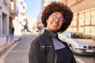 African american woman smiling confident looking to the sky at street