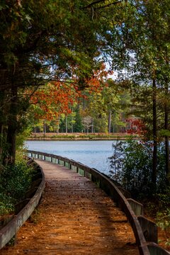 Vertical of a pier on lake against autumn trees at Cheraw State Park in Chesterfield, South Carolina
