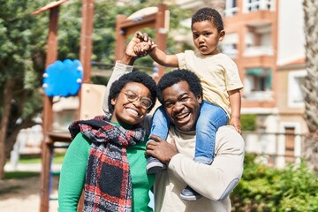 African american family holding boy on shoulders at playground