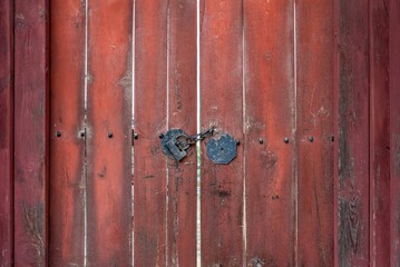 Wooden brown rural door with metallic rustic handles and a lock
