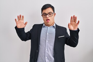Young hispanic man with down syndrome wearing business style disgusted expression, displeased and...