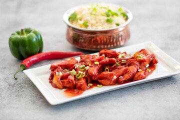 Delicious Sticky honey-soy ginger chicken on plate over dark stone background