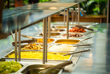 Asian food buffet in restaurant multiple food dishes and salad.