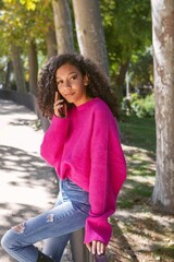 Vertical shot of a young girl talking on the phone while waiting for her boyfriend