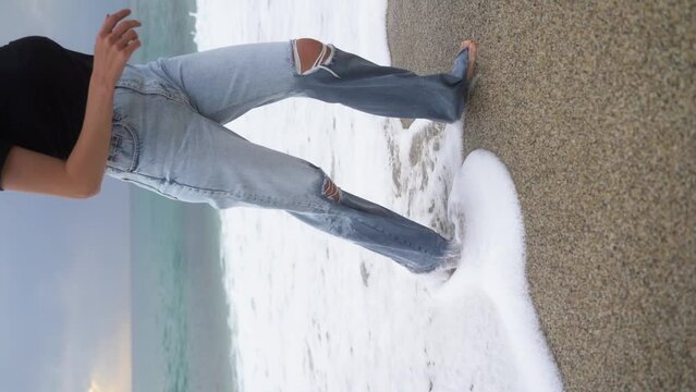 Young woman walks barefoot in the sea water alone. Romantic. Slow motion 120